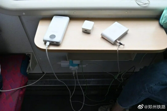 滞留列车的乘客在车上充电（来源：郑州铁路）