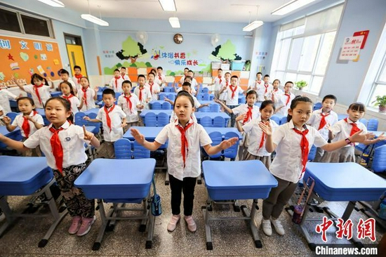 资料图：小学生们用手语操祝贺老师节日快乐。张云 摄