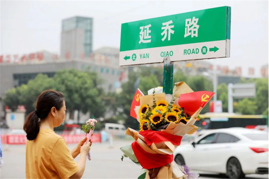  市民在“延乔路”路牌下献上鲜花、缅怀先烈。资料图