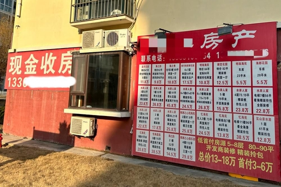 小区里随处可见的房产中介广告牌。摄影/孔海丽