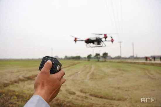 技术人员娴熟地操纵无人农机（央广网记者 胡斐 摄）