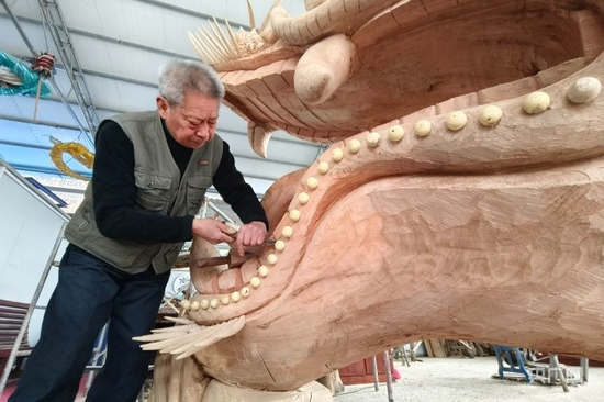  皇安东正在雕刻龙头（央广网见习记者 栾小琳 摄）