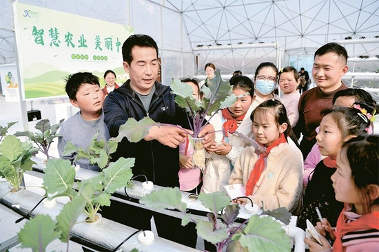 近年来，安徽省亳州市通过“公司+基地+农户”的方式，大力发展休闲观光农业，扎实推动乡村振兴。图为2023年3月4日，工作人员在智慧农业产业园内为参观者讲解有关技术。 人民图片 刘勤利/摄