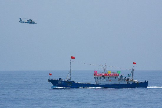 ↑中国海军第40批护航编队中的舰载直升机在被护船只周边海域巡逻警戒（2022年6月4日摄）。新华社发（唐文 摄）