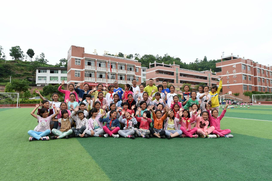  三河小学女子足球队队员与教练在学校操场上合影。（2016年5月30日摄）新华社记者 唐奕 摄