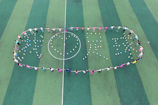 三河小学女子足球队队员在学校操场上用足球拼出“我爱足球”以表达自己的梦想。（2016年5月30日摄）新华社记者 唐奕 摄