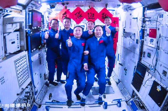 2023年5月30日在北京航天飞行控制中心拍摄的神舟十五号航天员乘组与神舟十六号航天员乘组拍下“全家福”的画面。新华社发（韩启扬 摄）