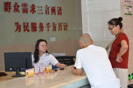  2024年9月24日，工作人员（左一）在重庆市沙坪坝区井口街道美丽阳光家园社区党群服务中心为市民服务。新华社记者 肖潇 摄