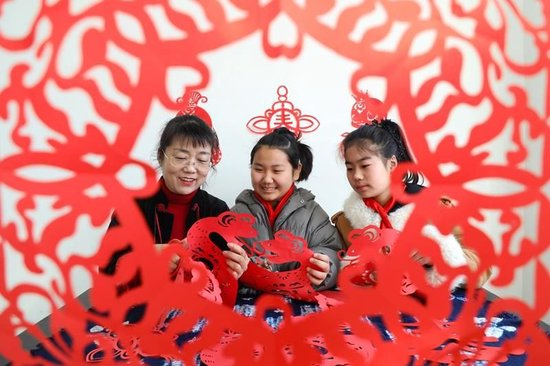 △2025年2月13日，在河北唐山一所小学举行的“非遗进校园”开学第一课主题活动中，剪纸艺人向学生传授剪纸技艺。