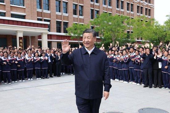 2024年6月18日,习近平总书记在青海果洛西宁民族中学考察时,向师生们挥手致意。