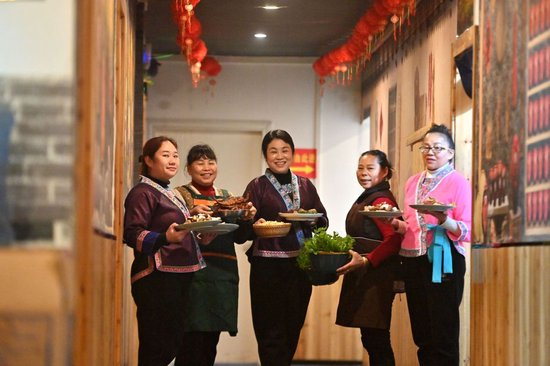 2025年2月28日，在广西柳州市融水苗族自治县融水镇一家餐馆，负责人吴葵花（中）和员工展示菜品。吴葵花经营餐馆22年，长期为当地农村群众提供稳定就业岗位，并收购偏远山区群众种植的蔬菜。在广西大山里，一批女能人活跃在农村电商、民宿餐饮、乡村文旅等各个领域，带动留守妇女发展产业，实现就近居家就业创业。新华社记者 黄孝邦 摄