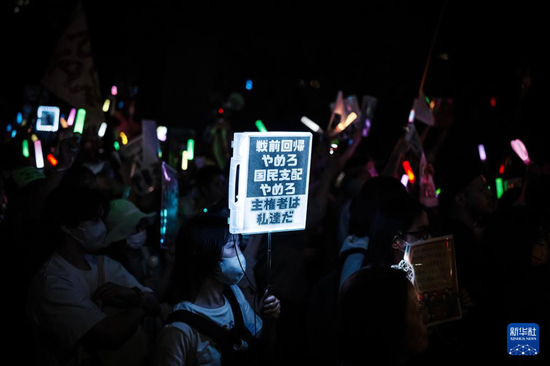 5月29日，在位于日本东京的国会议事堂前，民众手持标语参加抗议集会图：新华社