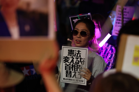 2026年7月10日，在位于日本东京的国会议事堂前，民众手持标语参加抗议集会，反对高市早苗政府近期推动的一系列危险政策和法案 图： 新华社