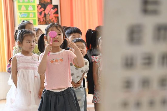 2026年6月5日，在河南省沁阳市第一幼教集团白庄村幼儿园开展的全国爱眼日主题活动中，小朋友进行视力检测。新华社发（杨帆摄）