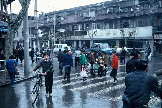 △ 1983年，上海，阴雨天，行人在淮海中路上穿梭。