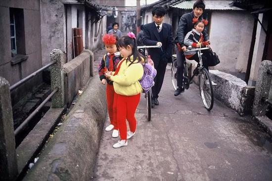 △ 1985年，苏州，穿戴漂亮的小女生在石板桥上行走。