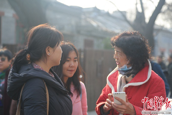 2月23日，中央戏剧学院，考生家长在学校门外等考生时，拿起手机分享备考经验。