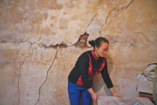 　　▲村民王仕杰家，4米长呈对角线状的一处位于中寨断裂带的房屋墙体开裂严重。 裂缝贯穿墙体，裂缝最宽处有3厘米，透光。