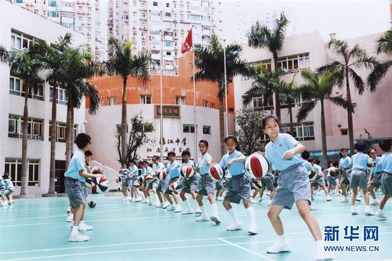 澳门濠江中学附属英才学校的小学生在学校操场运动（随信附赠的照片）。新华社发