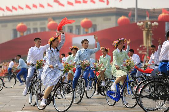 　　△游行共有三个篇章，每个篇章的结尾都设计了一个情境式行进。其中第一篇章“建国创业”在情境式行进“青春万岁”中结束，少男少女骑着自行车穿梭而过，汇成一道年代风景。（央视记者张淳拍摄）