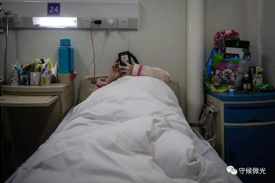 　　2月21日，武汉火神山医院感染八科，一位年轻的患者在病房内休息。出于安全考虑，患者病愈出院后，除了贵重物品外的大部分个人物品都无法带出病区。中青报·中青网记者李峥苨/摄
