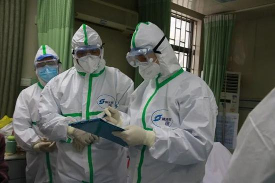  ▲仝小林院士（左手第二位）在武汉中西医结合医院急诊留观室查房，开具中药处方。