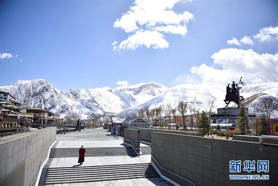 一名僧人在青海省玉树藏族自治州玉树市格萨尔广场旁走过地下通道（4月6日摄）。 新华社记者 吴刚 摄
