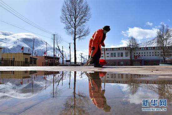 一名环卫工人在青海省玉树藏族自治州玉树市扎西大同村的广场清扫垃圾（4月6日摄）。新华社记者 吴刚 摄