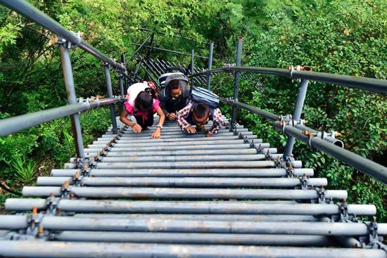 2017年11月5日，悬崖村的孩子们放学后攀爬天梯回家去。“钢梯上的求学梦”让这群孩子天晴下雨有了安全通道。