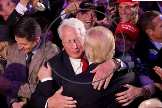  ·罗伯特（白发者）与特朗普拥抱在一起。