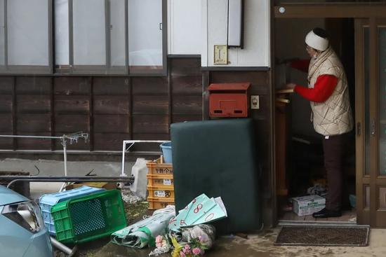 ▲2月15日，在日本福岛县二本松市，迟耒收拾家门口的物品。新华社记者 杜潇逸 摄