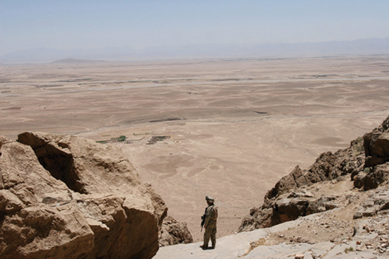 （图说：一名美军顾问在赫尔曼德省巡逻时，在一座山头上查看地势。图/AP）
