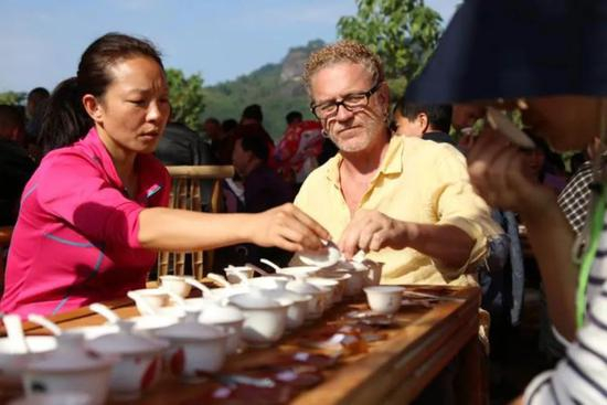 △2020年10月31日，福建省武夷山市，游客在九曲溪畔品茶。