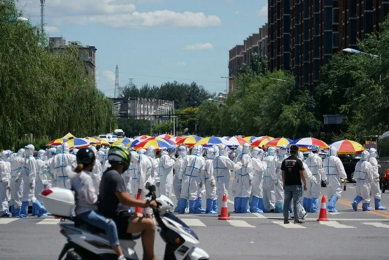 中午12点，又一批身着防护服的工作人员到达小区外。