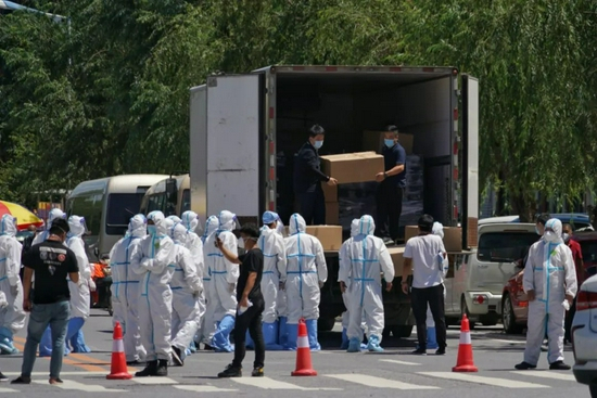 工作人员正从车上搬运物资。&nbsp;本组图片均由新京报记者 裴剑飞 摄