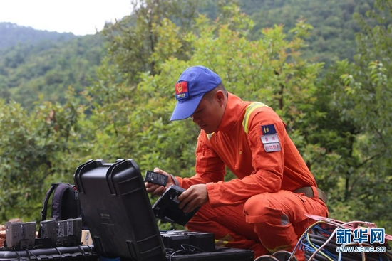 队员正在给无人机电池充电（摄于7月29日）。新华网发（郭元丰 摄）