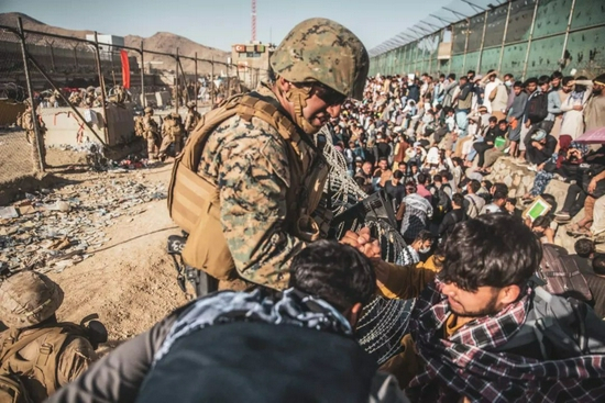  当地时间8月26日，阿富汗喀布尔，美军士兵在机场协助人员撤离。/IC photo