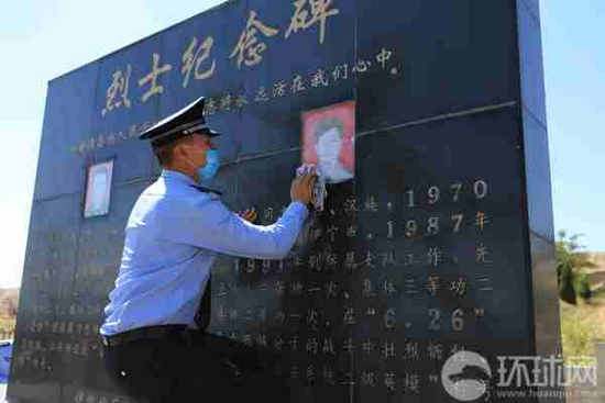 伊犁州公安局的干警在擦拭龙飞和孔永强烈士的纪念碑。摄影范凌志