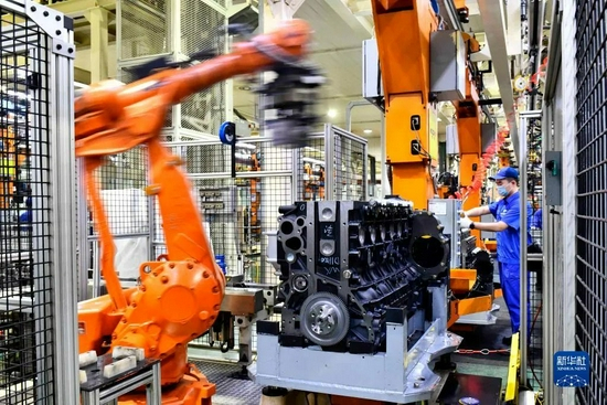 工人在流水线上装配发动机。图源：新华社