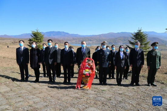 10月23日，在朝鲜咸镜南道西北部长津湖畔的长津邑中国人民志愿军烈士合葬墓地，中国驻朝鲜大使馆外交官向烈士献花并默哀致敬。新华社记者 江亚平 摄