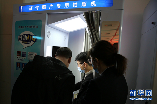  市民在赛罕区政务服务大厅“24小时政务服务超市”进行证件照片自助拍照。新华网 石毅 摄