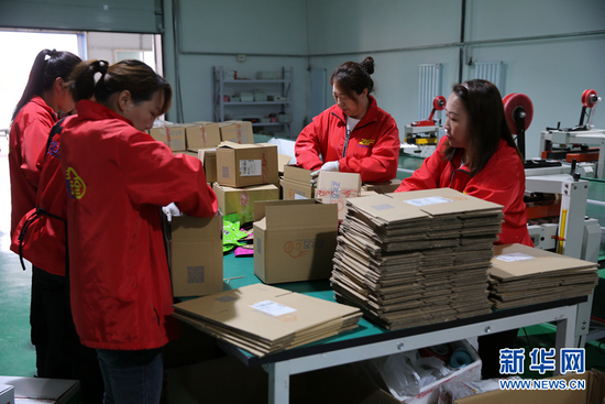 在赛罕区金河镇曙光村“正北方云仓”电商平台打包车间，工作人员正在分货装箱。新华网 石毅 摄