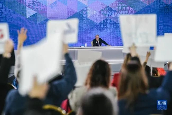 ·许多记者只能在“标语牌”后面找缝隙看普京。新华社发（叶甫盖尼·西尼岑摄）