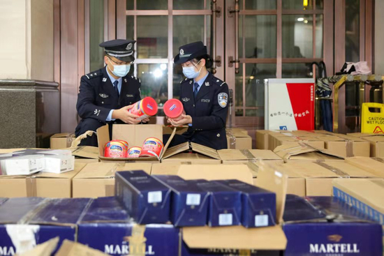  缉私警察正在清点查获的走私货物。图据新华社