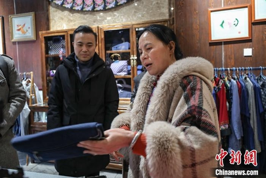  苗绣传承人石丽平在给游客介绍苗绣产品。 瞿宏伦 摄