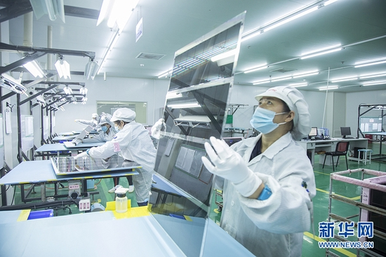  赫得纳米科技黄石公司生产车间内，工人对产品进行检测。新华网发