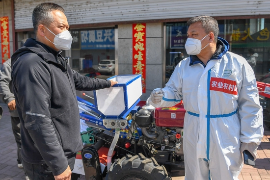 4月13日，在吉林市桦皮厂镇，吉林市农业机械化技术推广中心主任张守国（右）指导农民选购农机。吉林市农业农村局开辟备春耕运输“绿色通道”，将农资农机按时按需送到农民所在村屯。新华社记者 张楠 摄