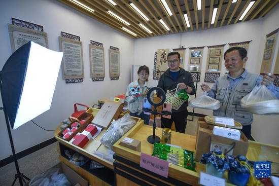  在杭州市湍口镇三联村，党员志愿者方刚（中）在乡贤工作室的直播间和村民一起直播推介农特产品（3月16日摄）。新华社记者 徐昱 摄