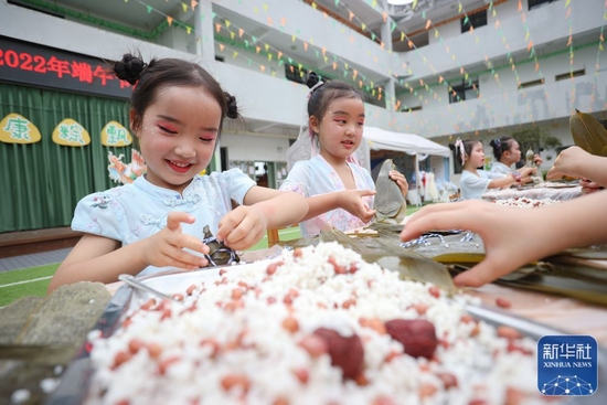 6月2日，四川省遂宁市大英县天星幼儿园的孩子们在老师带领下学习包粽子。新华社发（刘昌松摄）