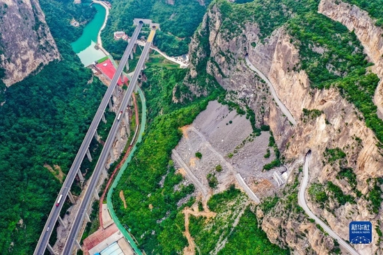 这是通过山西省长治市平顺县虹梯关乡的高速公路（画面左侧），一旁是过去的“挂壁公路”（画面右侧）（2022年7月5日摄，无人机照片）。新华社记者 曹阳 摄